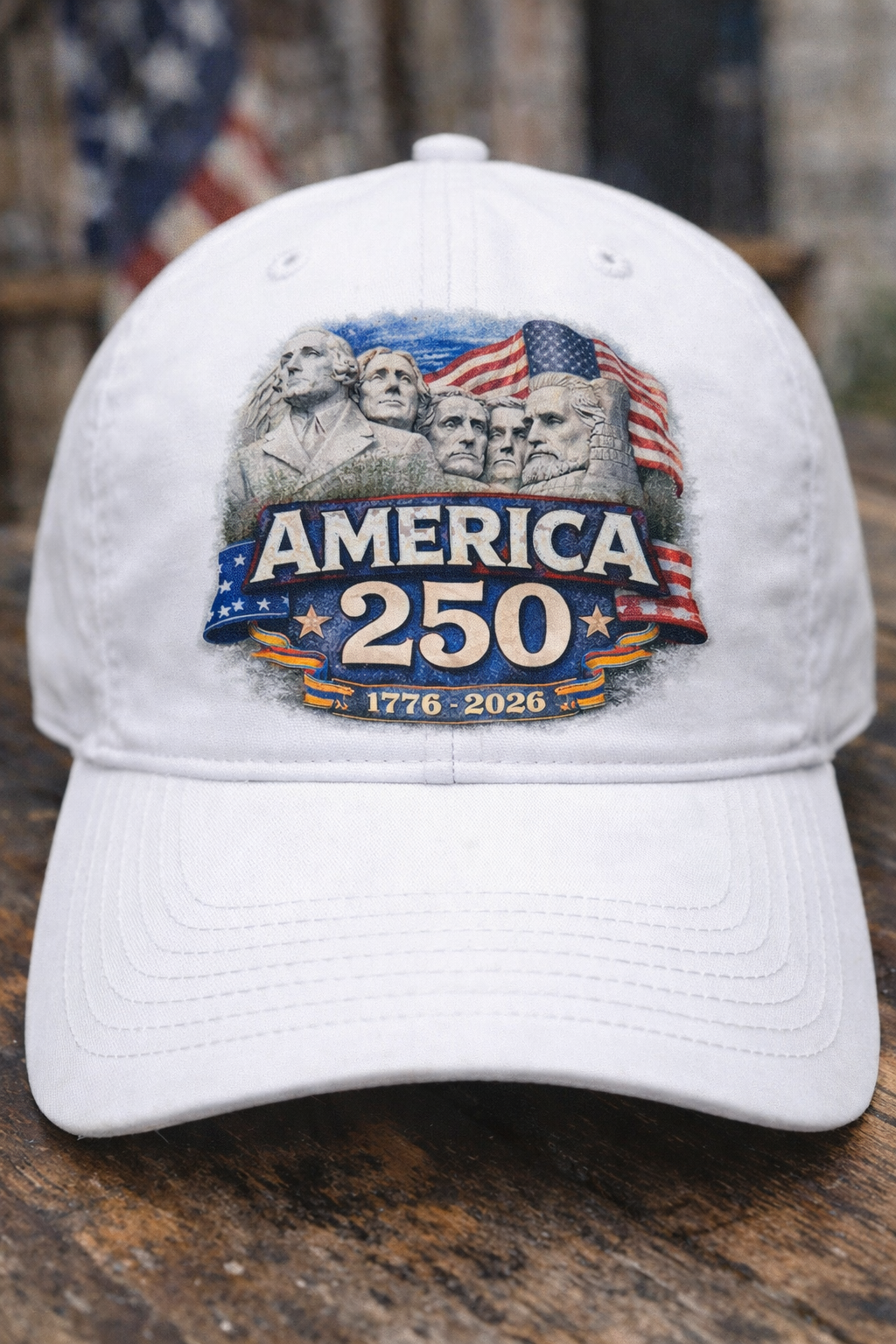 White cap with America 250 DTF Transfer Bundle - Mount Rushmore America 250 DTF Transfer on a wooden surface with American Flag in Background